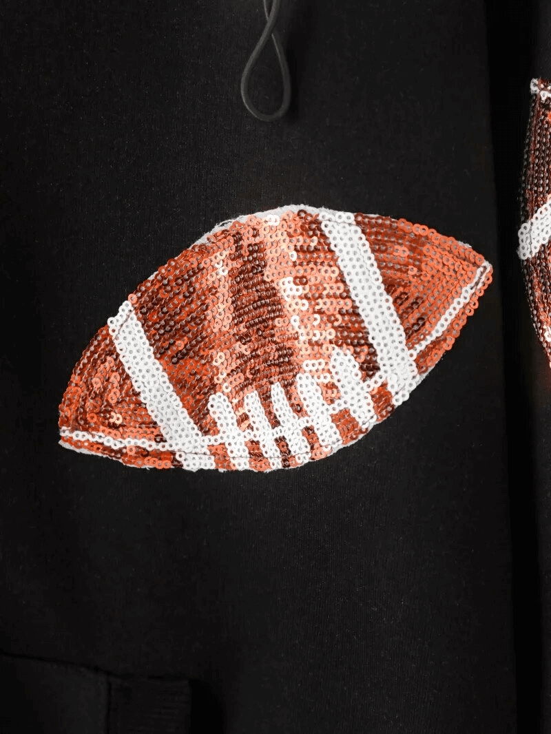 Close-up of sequin football design on black sporty women's hoodie, highlighting the sparkling detail.